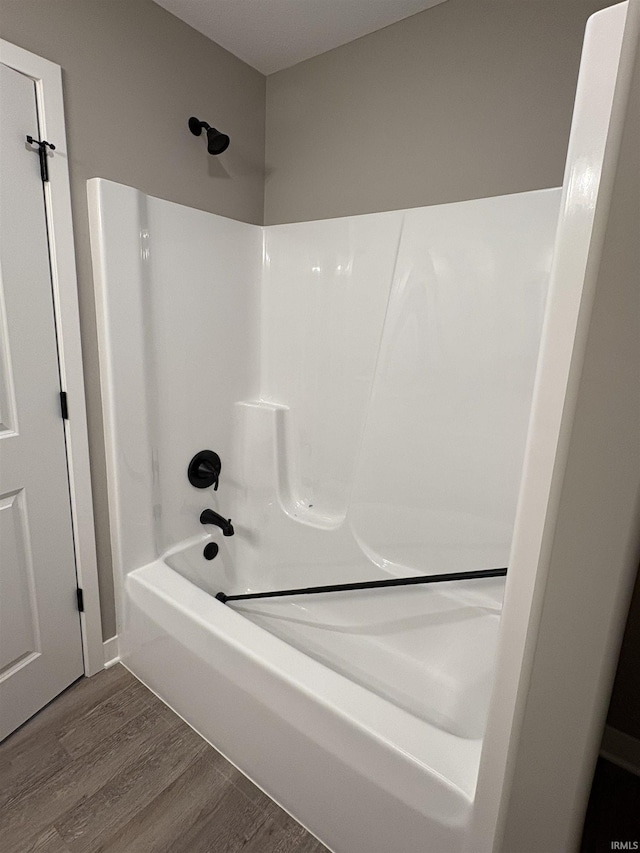 bathroom featuring washtub / shower combination and wood finished floors