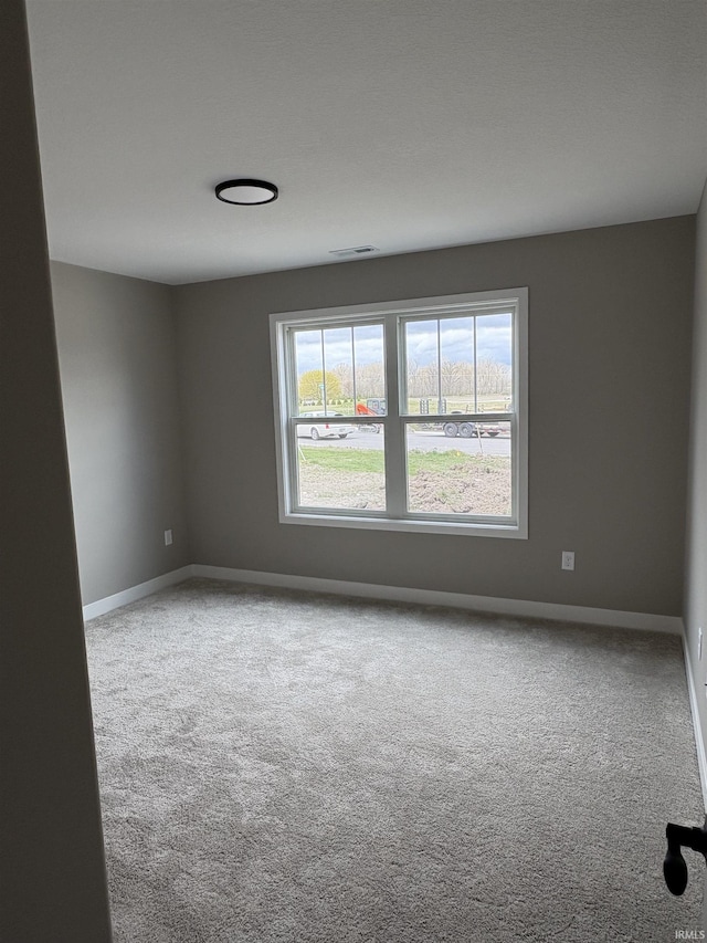spare room with baseboards and carpet flooring