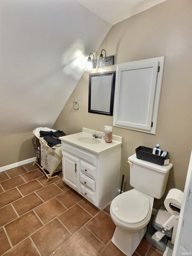 bathroom featuring tile patterned floors, vanity, toilet, and lofted ceiling