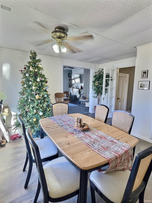 dining space featuring a paneled ceiling, hardwood / wood-style flooring, and ceiling fan