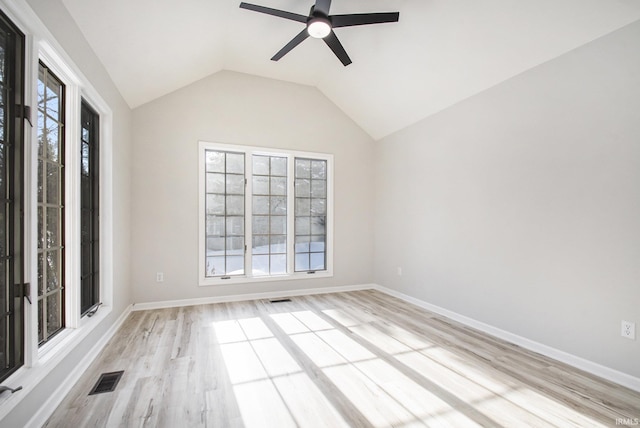 unfurnished room with light wood-type flooring, a wealth of natural light, lofted ceiling, and ceiling fan