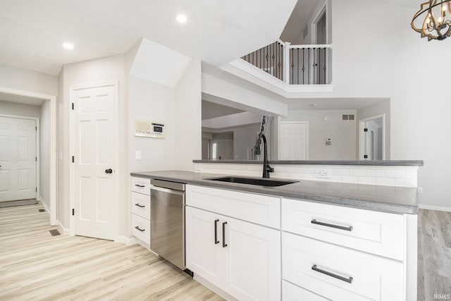 kitchen with sink, a notable chandelier, dishwasher, light hardwood / wood-style floors, and white cabinetry