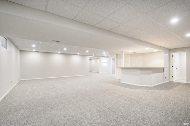 basement with carpet flooring and a drop ceiling