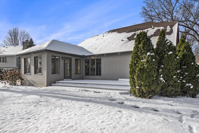 view of snow covered rear of property