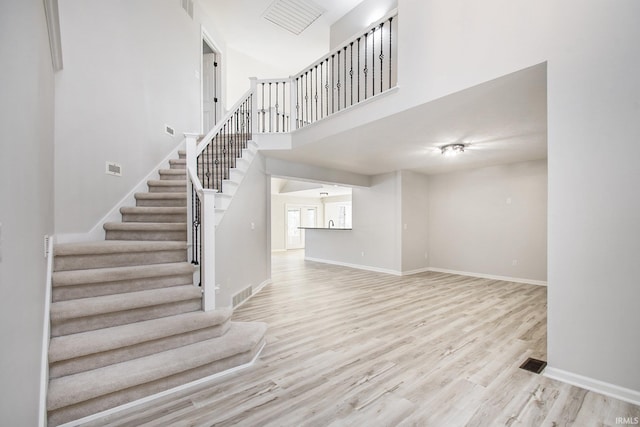 stairway with a high ceiling and hardwood / wood-style flooring