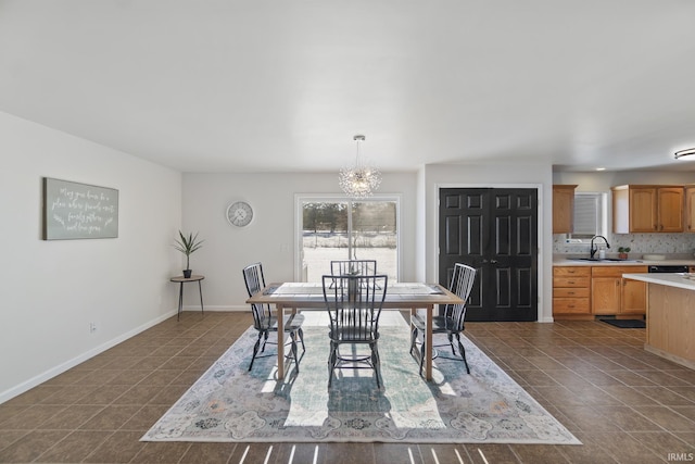 tiled dining area featuring sink and an inviting chandelier