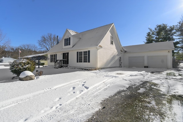 snow covered house featuring a garage