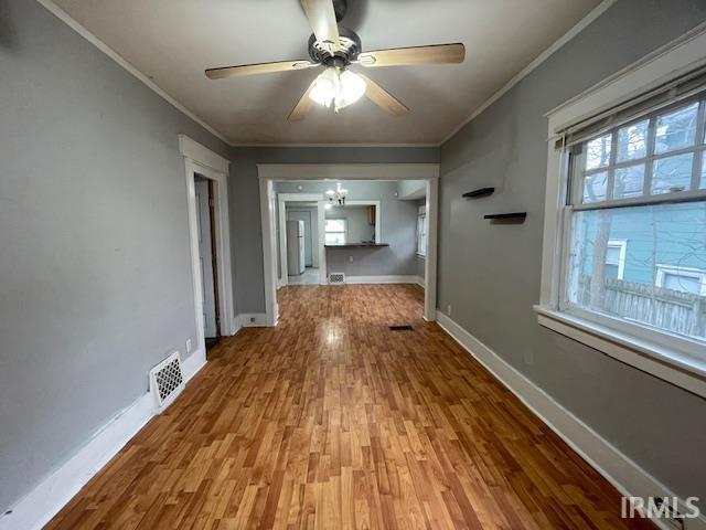 corridor featuring wood-type flooring and ornamental molding