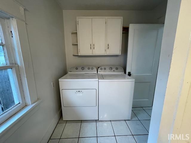 laundry room with washer and dryer, cabinets, plenty of natural light, and light tile patterned floors