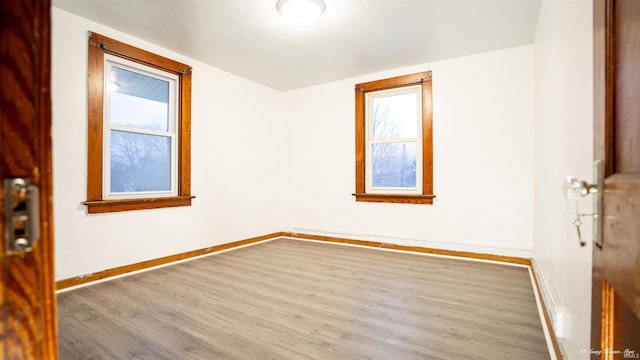 unfurnished room with hardwood / wood-style flooring