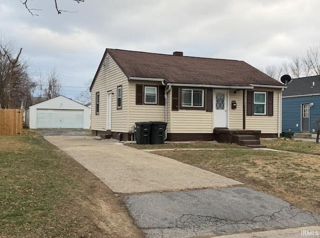 bungalow-style house with a front yard, an outdoor structure, and a garage