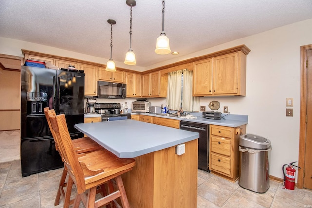 kitchen with black appliances, a center island, hanging light fixtures, and a textured ceiling