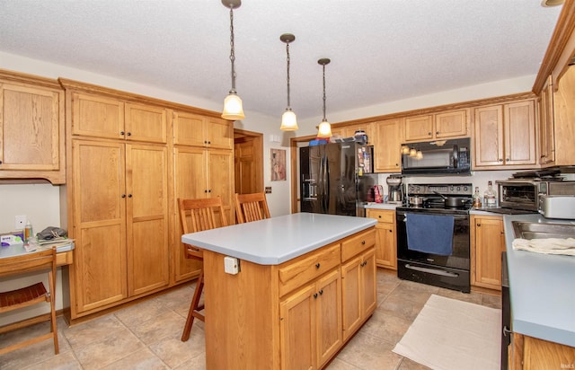 kitchen featuring a textured ceiling, black appliances, light tile patterned floors, a center island, and hanging light fixtures