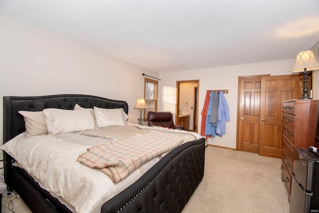 bedroom with light colored carpet and a textured ceiling