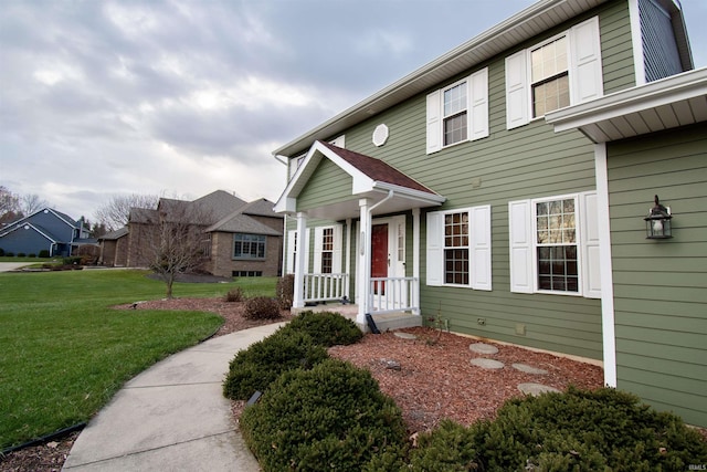 view of front of home with covered porch and a front lawn