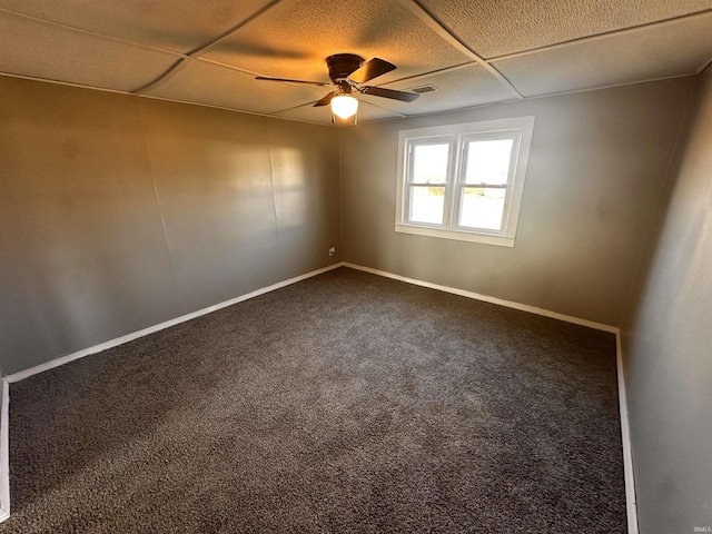 carpeted spare room featuring ceiling fan and a paneled ceiling