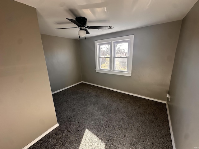 unfurnished room with ceiling fan and dark carpet