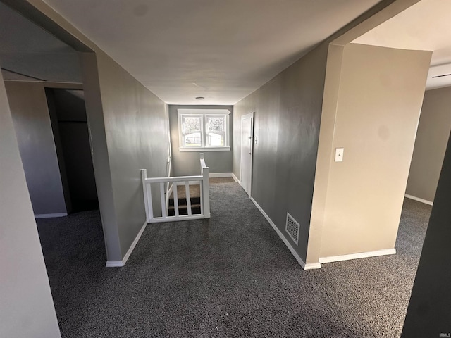 hall featuring dark colored carpet