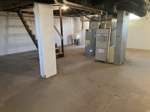 basement featuring sink, electric water heater, and heating unit