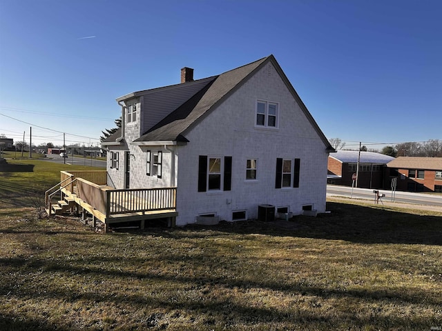 back of house featuring central AC, a wooden deck, and a yard