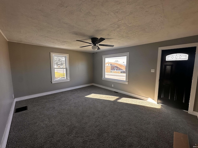 carpeted entrance foyer featuring a textured ceiling and ceiling fan