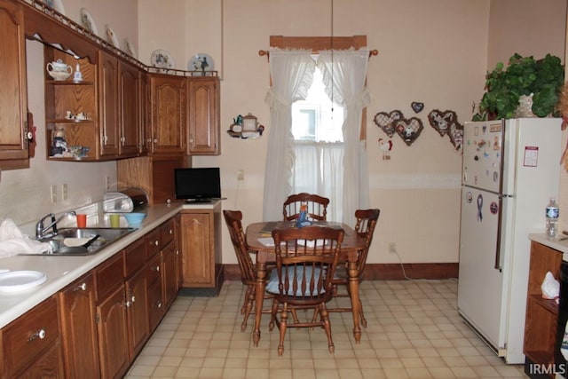 kitchen featuring pendant lighting, white fridge, and sink