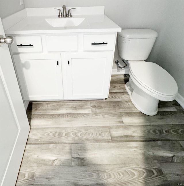 bathroom featuring hardwood / wood-style flooring, vanity, and toilet