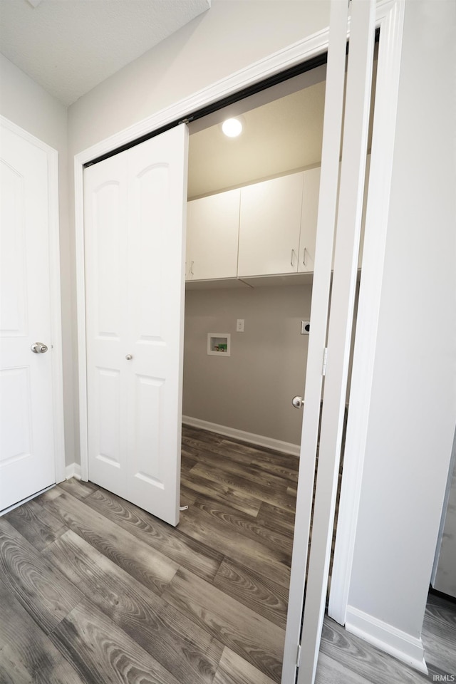 washroom with hookup for a washing machine, dark hardwood / wood-style flooring, and cabinets