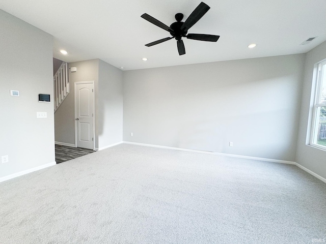 unfurnished room with dark colored carpet and ceiling fan