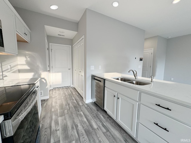 kitchen featuring sink, light hardwood / wood-style flooring, stainless steel dishwasher, electric range oven, and white cabinetry