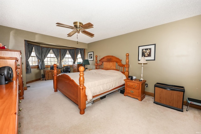 bedroom featuring light carpet, a textured ceiling, and ceiling fan