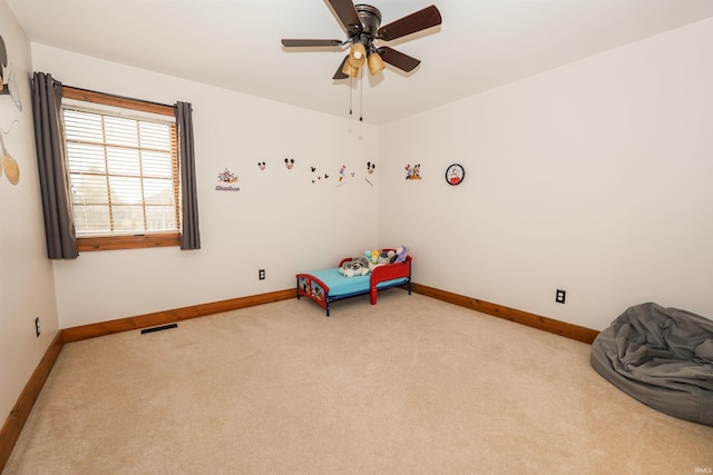 interior space with ceiling fan and light colored carpet