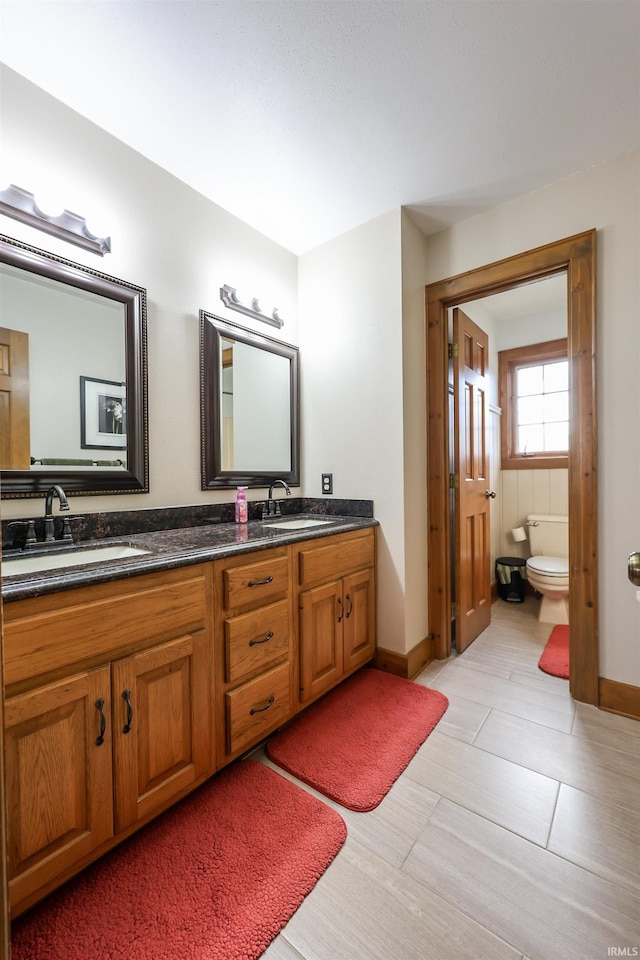 bathroom featuring tile patterned flooring, vanity, and toilet