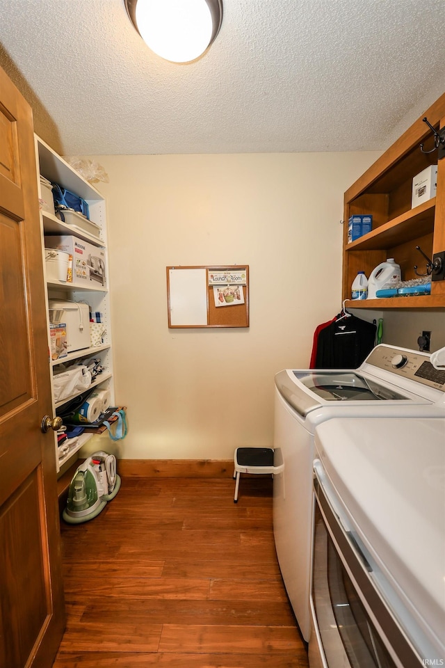 laundry room with dark hardwood / wood-style flooring, independent washer and dryer, and a textured ceiling