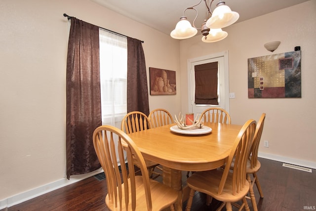 dining space featuring dark hardwood / wood-style flooring and an inviting chandelier