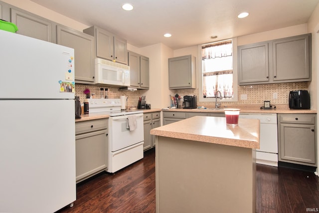 kitchen with white appliances, a center island, dark wood-type flooring, and backsplash