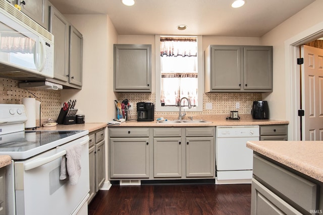 kitchen with plenty of natural light, dark hardwood / wood-style floors, white appliances, and sink