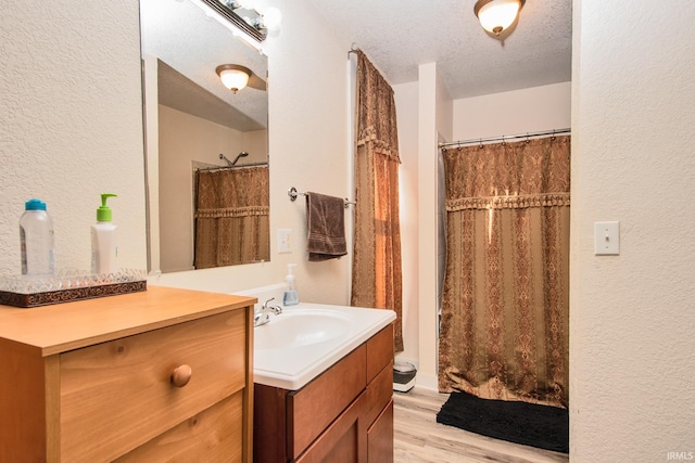 bathroom with hardwood / wood-style floors, vanity, and a textured ceiling