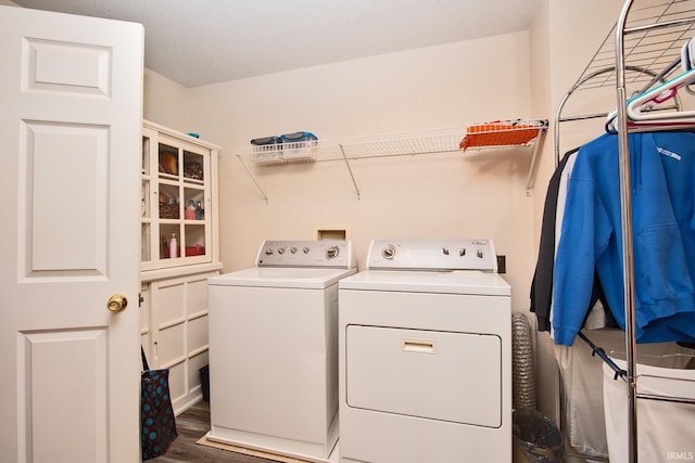 washroom featuring dark hardwood / wood-style flooring and washing machine and clothes dryer