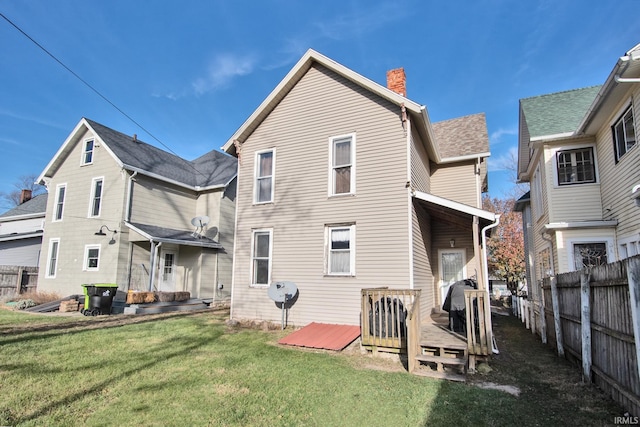 back of house with a lawn and a wooden deck