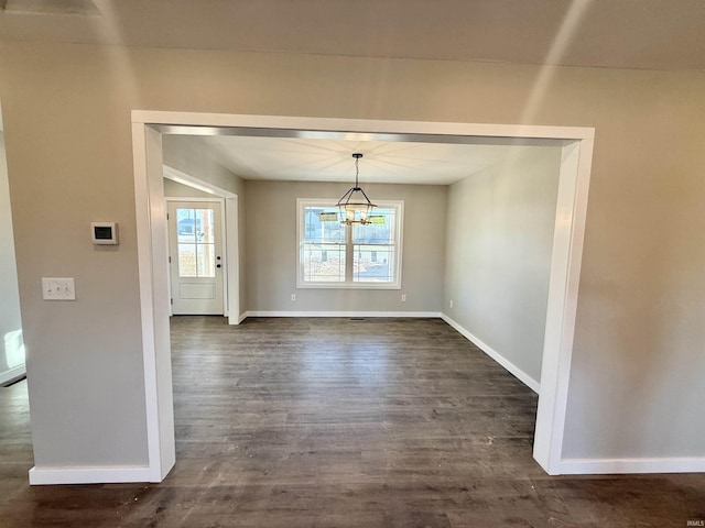 unfurnished dining area with dark wood-type flooring and a notable chandelier