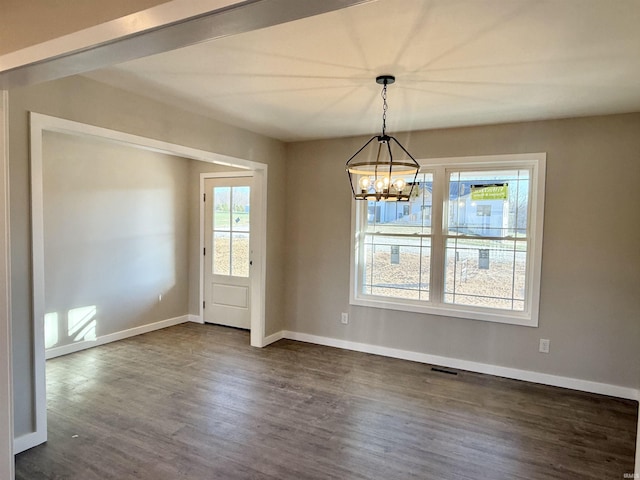 unfurnished dining area featuring dark hardwood / wood-style floors and an inviting chandelier