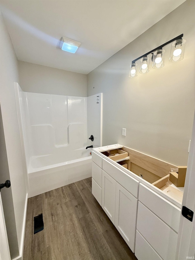 bathroom featuring wood-type flooring and shower / tub combination