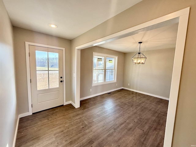 doorway to outside featuring dark wood-type flooring and a notable chandelier