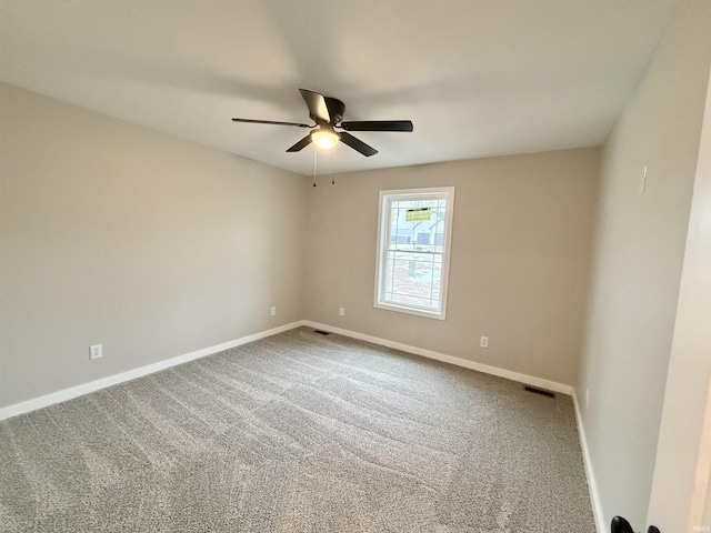 carpeted spare room featuring ceiling fan