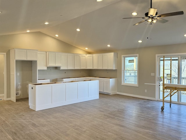 kitchen featuring ceiling fan, a center island, light hardwood / wood-style flooring, and white cabinets