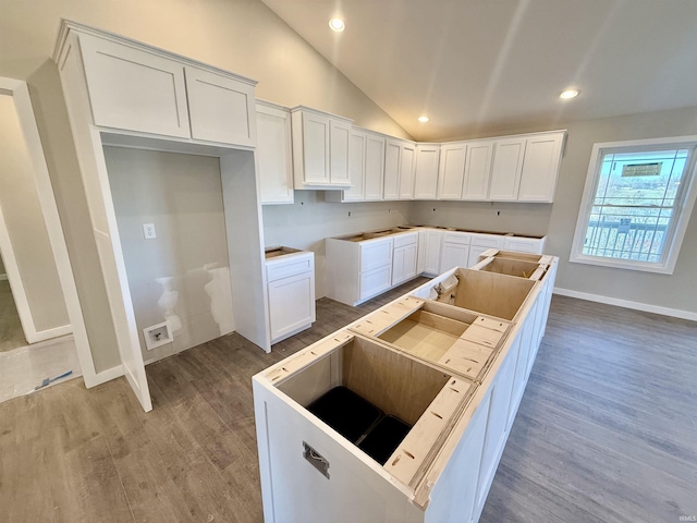 kitchen with white cabinetry, lofted ceiling, and a center island