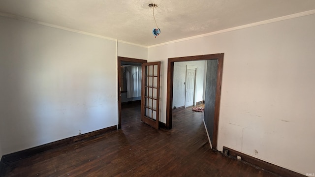 empty room featuring dark wood-type flooring and ornamental molding