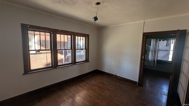 spare room featuring crown molding, dark hardwood / wood-style flooring, and a textured ceiling