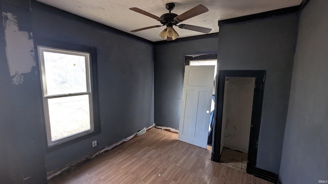 empty room with hardwood / wood-style flooring, ceiling fan, and a healthy amount of sunlight